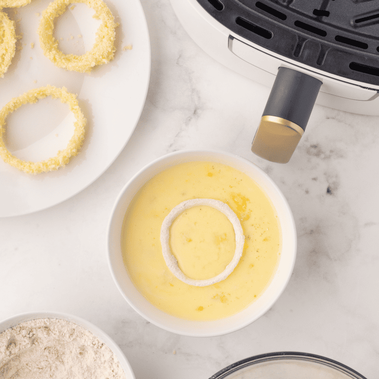 Coating onion rings with flour mixture, buttermilk-beer-egg mix, and Panko breadcrumbs for Air Fryer Beer Battered Onion Rings.