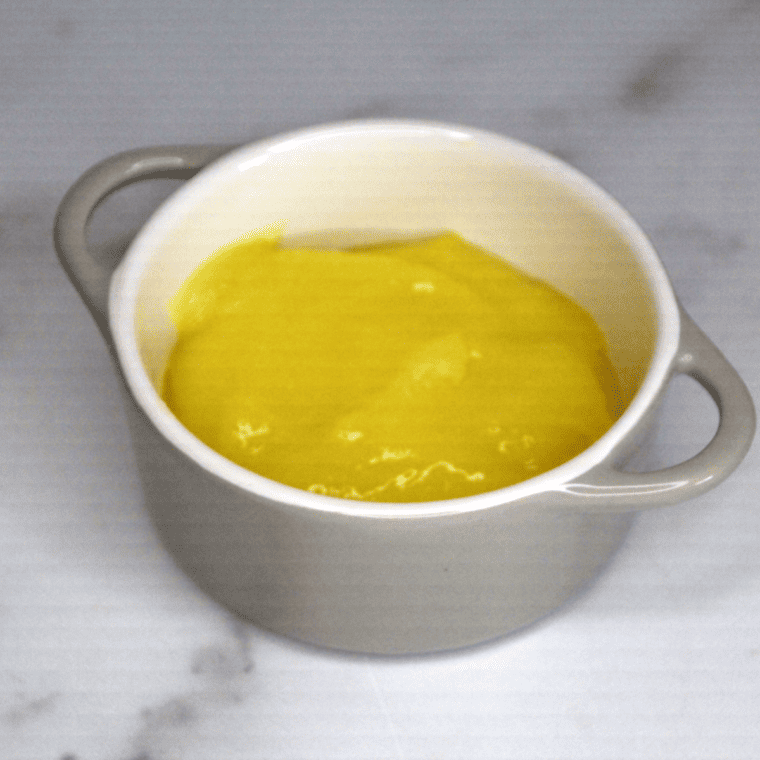 Spreading lemon pie filling evenly in a baking dish before adding cake mix for air fryer lemon dump cake.