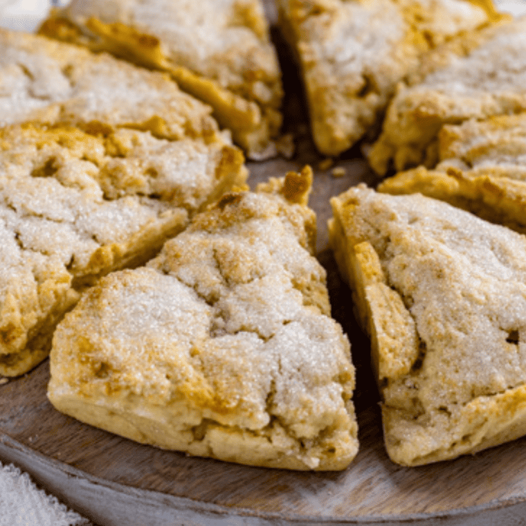 Freshly baked Air Fryer Lemon Scones with golden edges and a zesty glaze on top, served on a plate ready to eat.