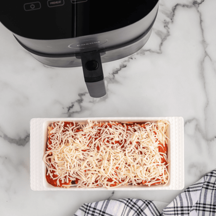 Final layer of mozzarella cheese on ravioli, ready to air fry.