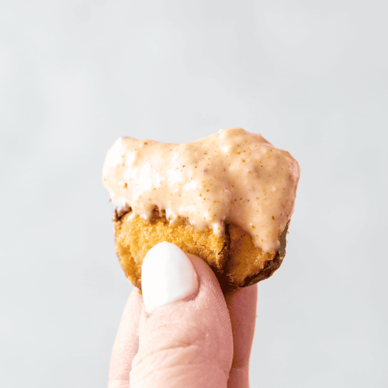 Fried pickle sauce in a ramekin with a pickle being dipped in