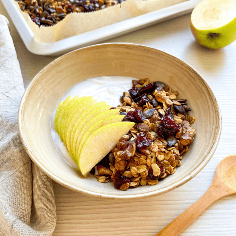 Vanilla Granola in a bowl with fruit, dried fruit, and yogurt.