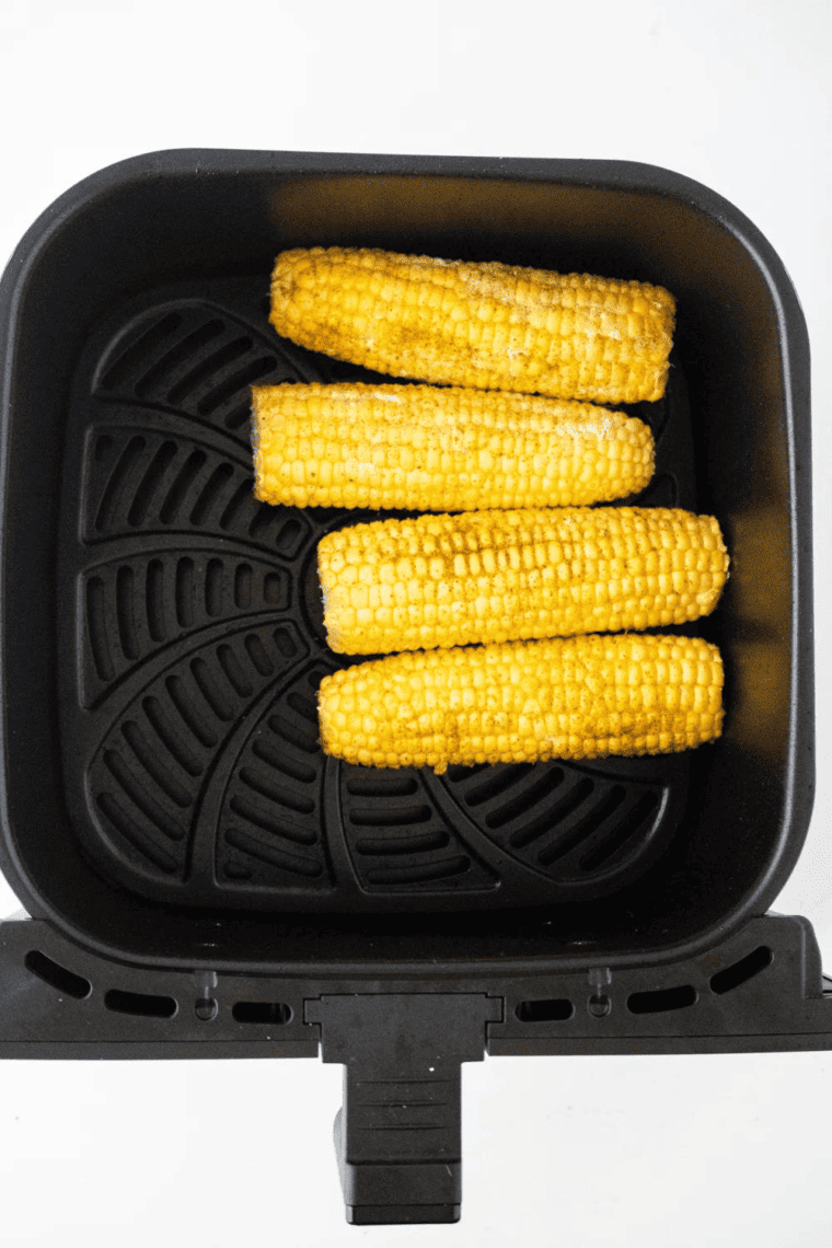 Air fryer Cajun corn, seasoned with spices, oil, and butter, cooked to tenderness and a slight char, topped with fresh parsley.