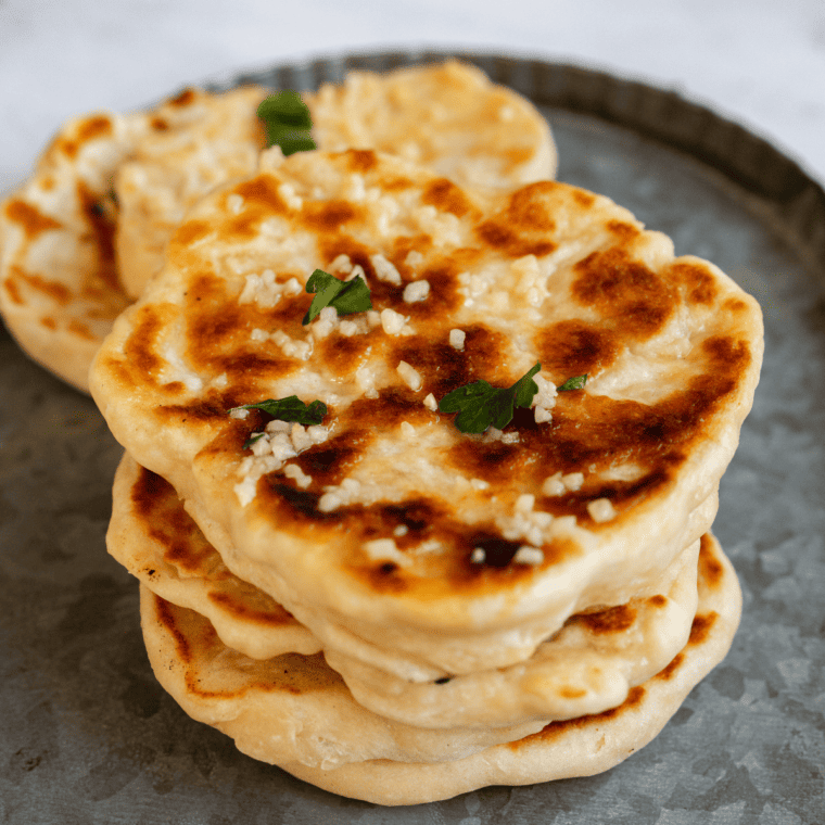 Freshly made Blackstone Naan, golden brown and soft, cooked on a griddle and ready to serve