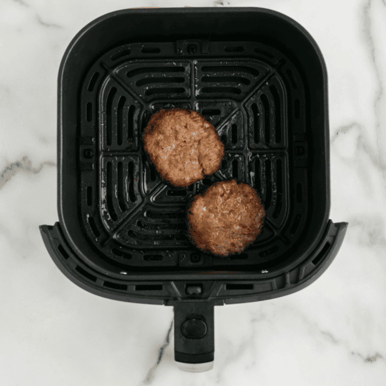 Cooking the sausage patty in a skillet until browned.