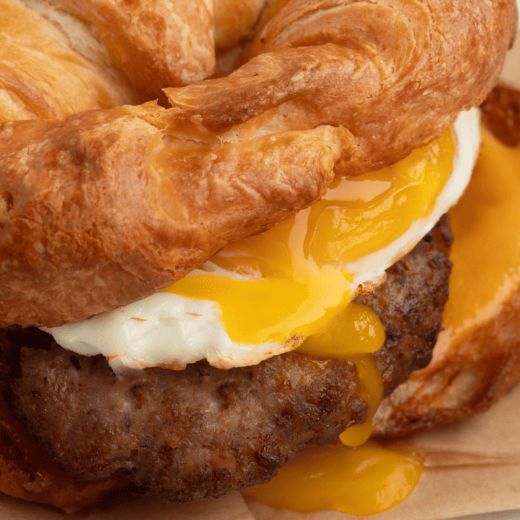 Homemade Burger King Sausage Egg and Cheese Croissan’wich with a golden croissant, sausage patty, scrambled eggs, and melted cheese.