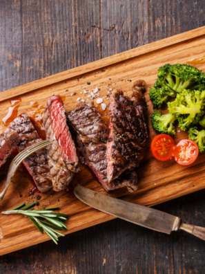 Homemade Heinz 57 steak sauce in a small glass jar beside sliced steak on a wooden cutting board