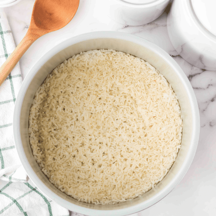 Adding rinsed rice and water to the Ninja Foodi for pressure cooking.