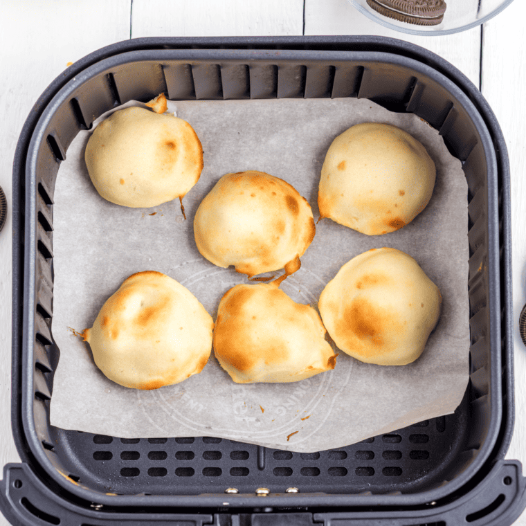 Air fried Oreos dusted with powdered sugar, drizzled with chocolate or caramel, garnished with sprinkles.