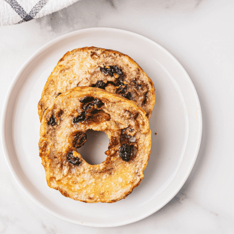 Finished Air Fryer Cinnamon Raisin Bagels topped with cinnamon and raisins"