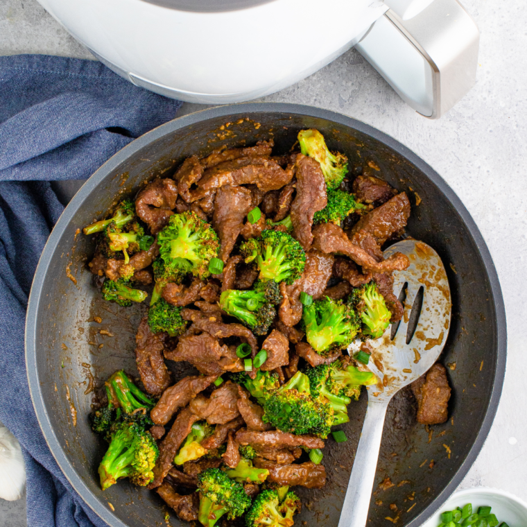 Air Fryer Beef and Broccoli served with tender beef and crispy broccoli, topped with a savory sauce and garnished with sliced scallions.