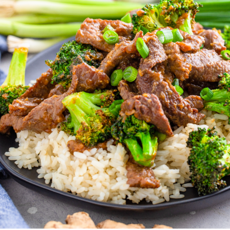 A plate of Air Fryer Beef and Broccoli with tender beef, crispy broccoli, and a savory sauce, garnished with fresh scallions.