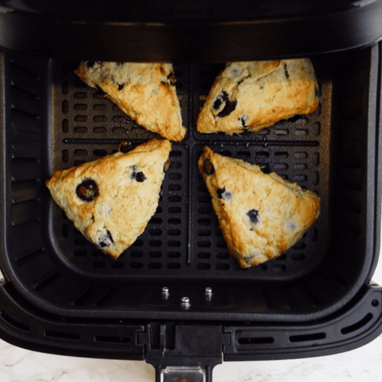 Freshly cooked scones with golden tops and bursts of blueberry, ready to glaze