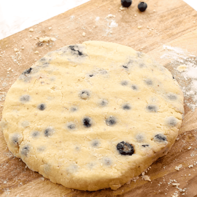 Shaping the scone dough into a 6-inch circle on a floured surface and cutting it into eight wedges