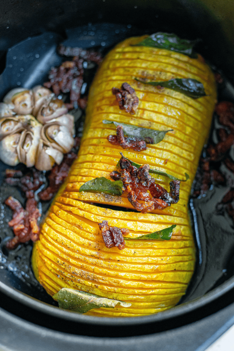 Air Fryer Butternut Squash Halves on a rustic wooden table, beautifully plated with a side of greens.