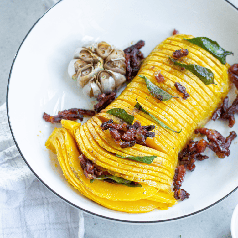 Air Fryer Butternut Squash Halves on a rustic wooden table, beautifully plated with a side of greens.