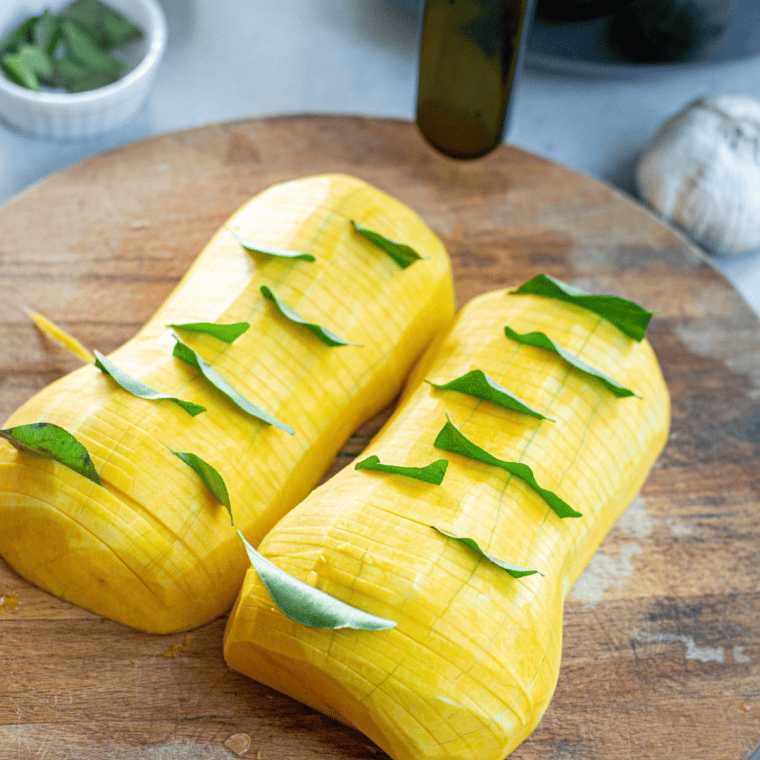 A close-up of Air Fryer Butternut Squash Halves on an a plate, with other ingredients. 
