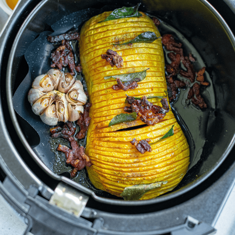 Golden brown Air Fryer Butternut Squash Halves after cooking, displayed on a plate for serving.