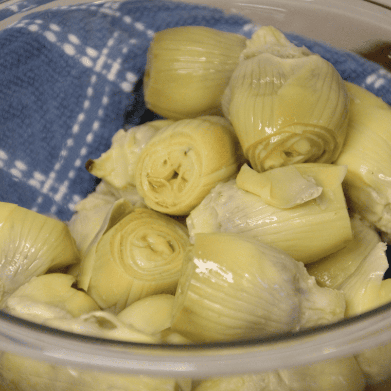 Patting canned artichoke hearts dry with a paper towel for crispier air fried artichokes.