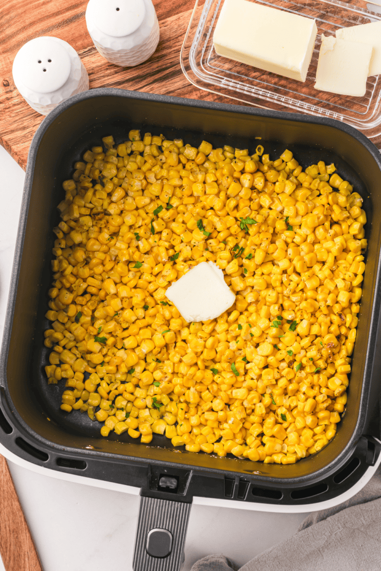 Air Fryer Canned Corn cooked to crispy perfection, seasoned with butter, garlic powder, salt, and pepper.