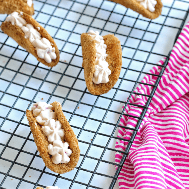 Fill the cooled taco shells with the cheesecake filling and then top with a couple of teaspoons of pie filling.