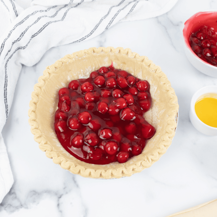 Pressing a thawed pie crust into the bottom of a pie pan for air fryer cherry pie