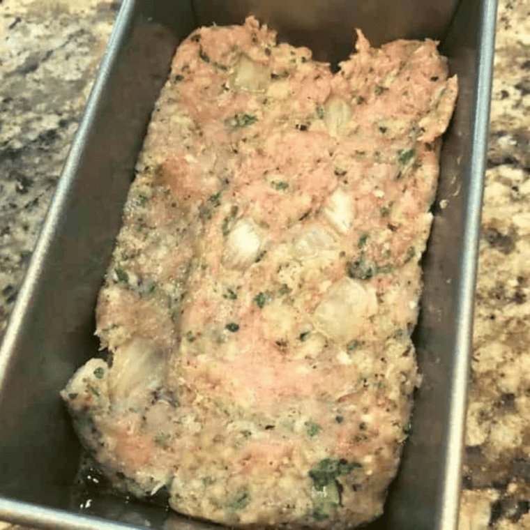Mix Ingredients: A bowl filled with ground chicken, breadcrumbs, egg, and seasonings being mixed together for the meatloaf.