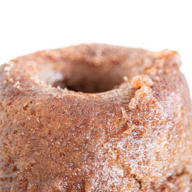 Warm air fryer churro donut being brushed with butter and rolled in cinnamon sugar