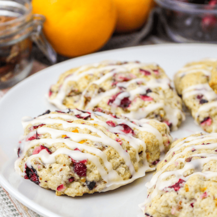 Stack of golden cranberry orange scones with orange glaze