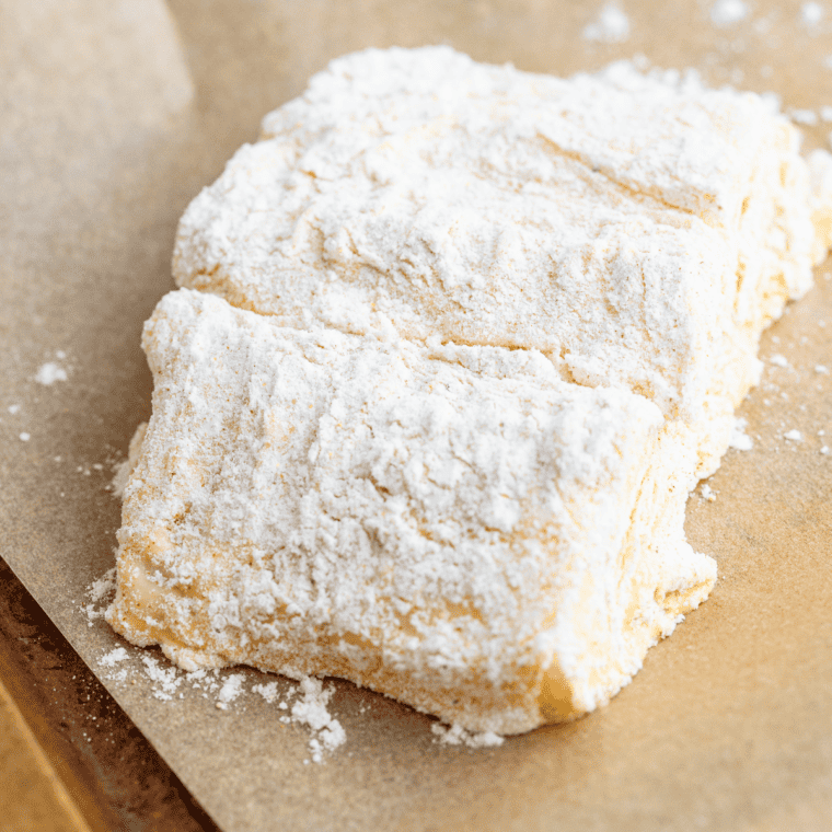 Coating cod fillets in batter and flour before air frying.