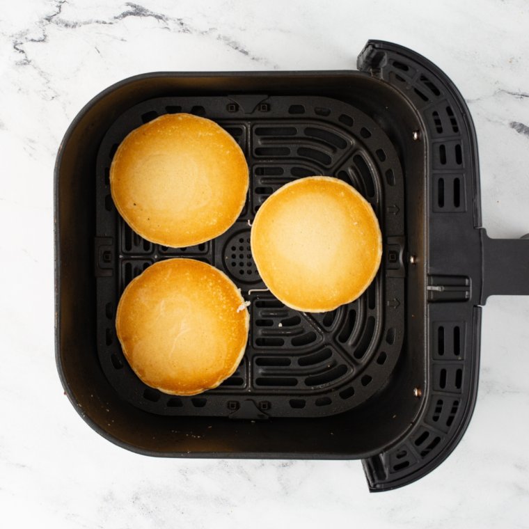 Frozen pancakes arranged in single layer inside air fryer basket
