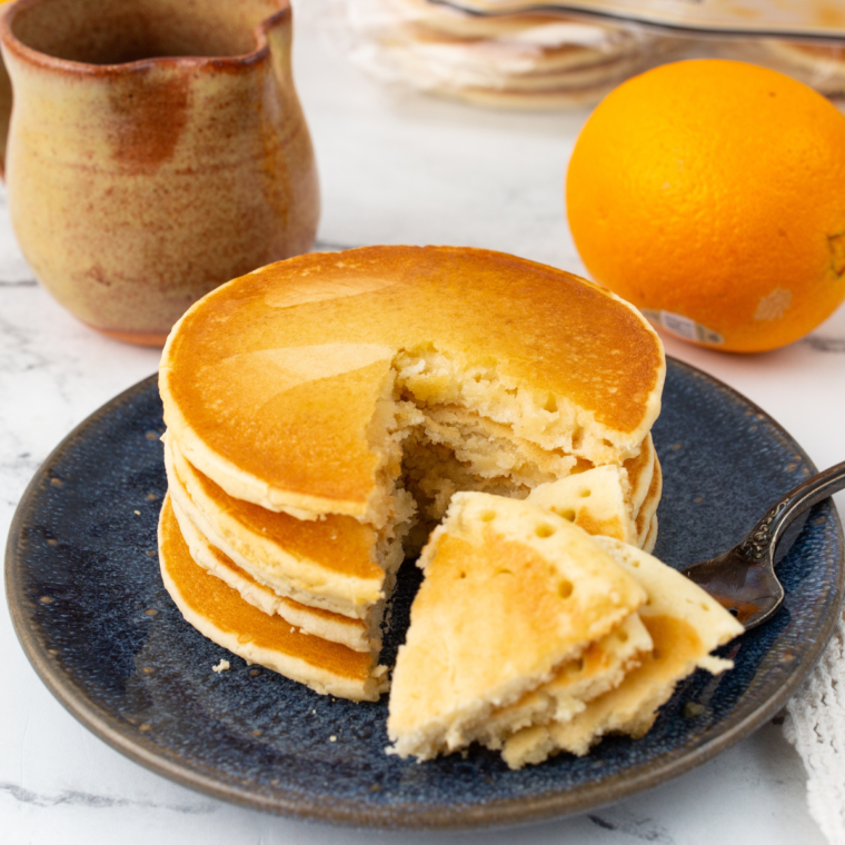 Stack of air fryer frozen pancakes topped with butter and syrup
