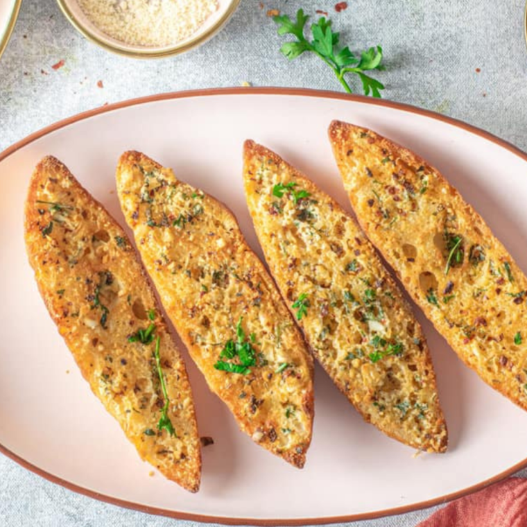"Finished air fryer garlic bread, golden brown and bubbling, in the air fryer basket.