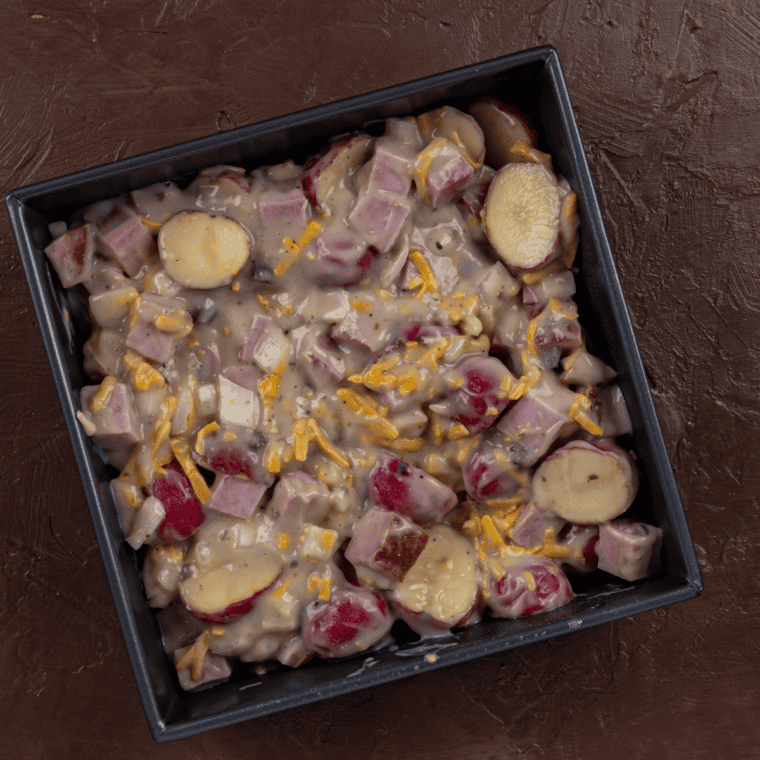 Layering potato slices, diced ham, and cheddar into an air fryer–safe dish