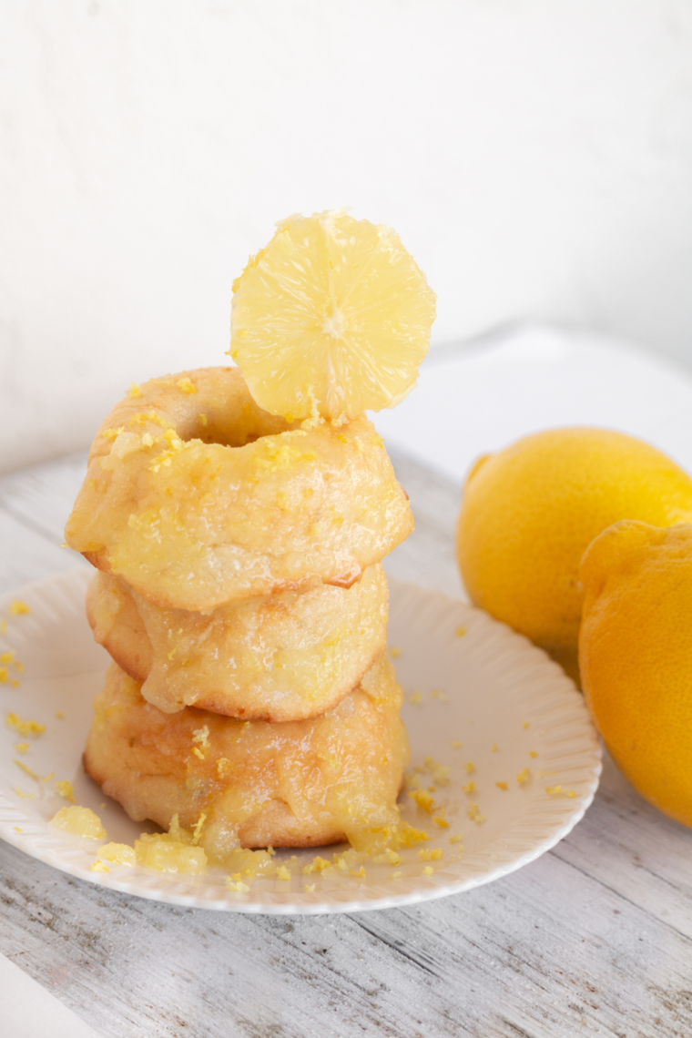 Light and fluffy air fryer lemon donuts with lemon glaze, stacked neatly on a white plate