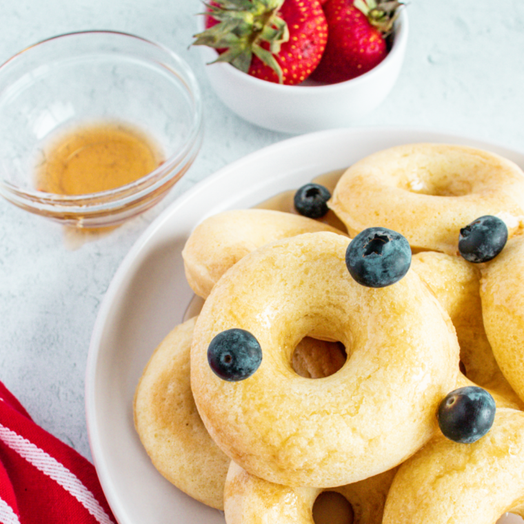 Pancake donuts in air fryer mold rising and turning golden brown.
