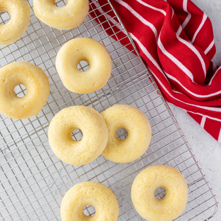 Golden air fryer pancake donuts dusted with sugar on cooling rack