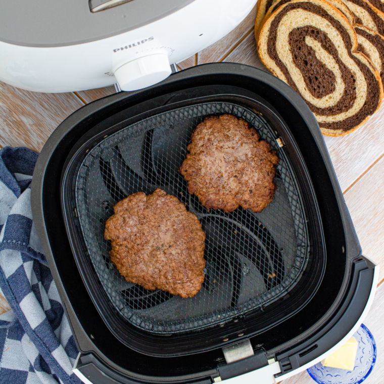 Juicy cooked beef patty for an air fryer patty melt resting on parchment.