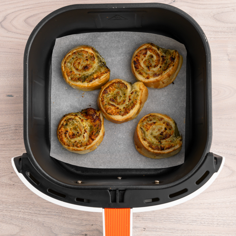"Serving plate of Air Fryer Pesto Pinwheels with crispy edges and golden color."