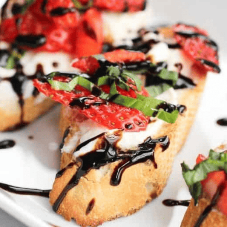 Close-up of strawberry mascarpone bruschetta showing creamy cheese and sliced strawberries on toasted baguette