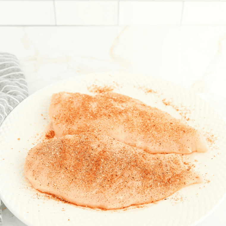 Thin chicken breasts seasoned with oil, salt, and pepper before air frying