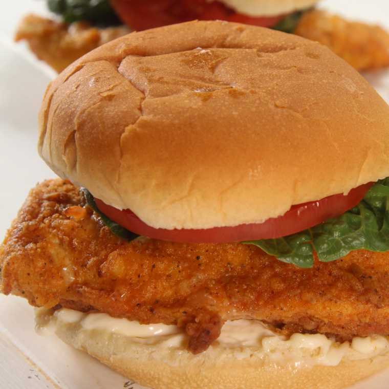 Air fryer Wendy's Spicy Chicken Sandwich with crispy chicken, lettuce, tomato, pickles, and mayonnaise on a toasted hamburger bun.