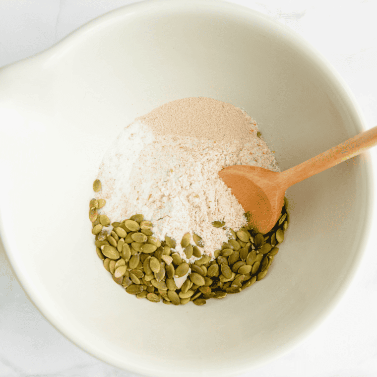 Whole wheat flour, yeast, salt, and sunflower seeds combined in a mixing bowl