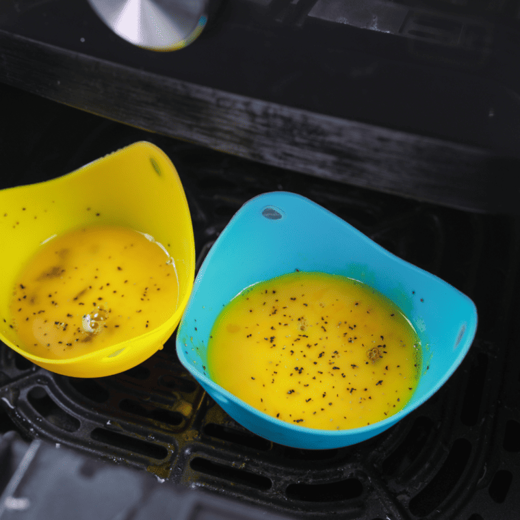 Cracking eggs into ramekin with salt, pepper, and optional cream for rich air fried baked eggs preparation