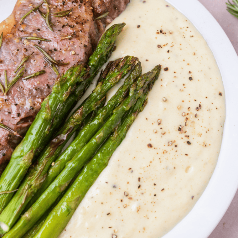 Close up of plate of Ninja Speedi Asparagus with mashed potatoes and steak.