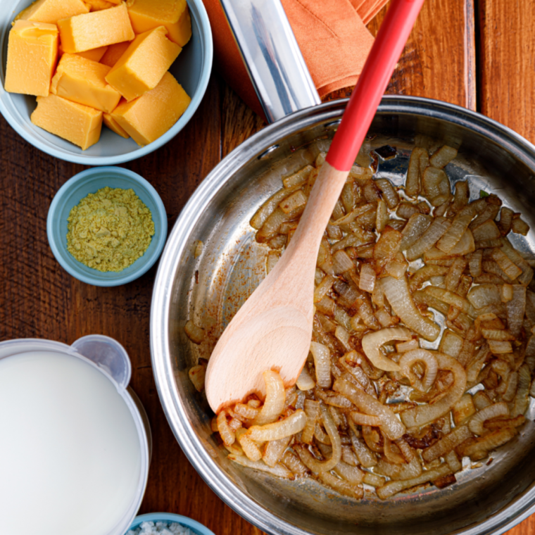Sliced onions cooking in melted butter in a large pot until soft and caramelized, about 10–15 minutes.