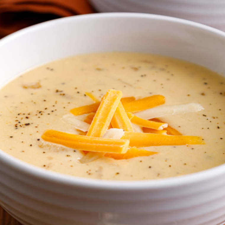A bowl of Copycat Outback Steakhouse Walkabout Soup garnished with melted cheese and fresh herbs.