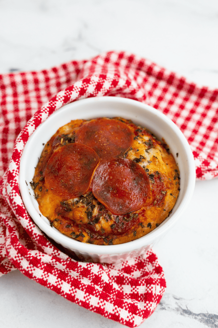 Cheesy Air Fryer Pizza Dip bubbling in a dish, topped with pepperoni and herbs.