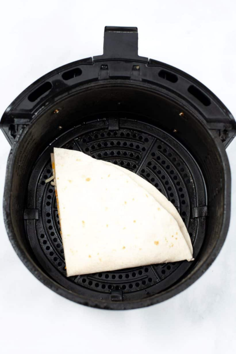 Cheesy air fryer quesadilla sliced on a plate with melted cheese and creamy jalapeño dipping sauce, Taco Bell copycat style.
