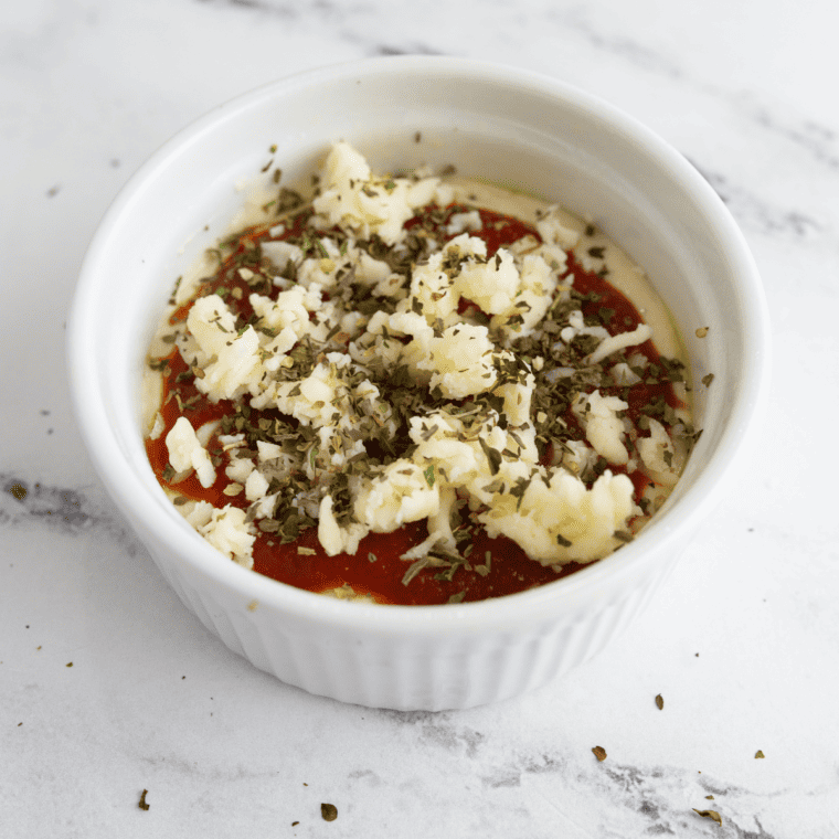 Mixing cheese and marinara sauce for Air Fryer Pizza Dip preparation.